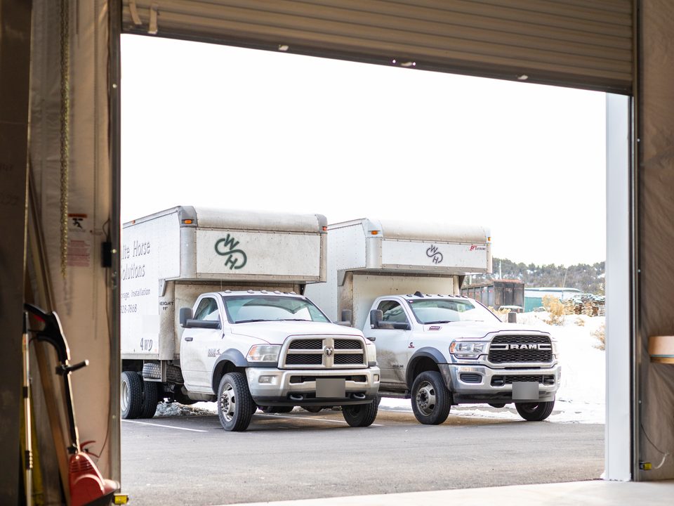 Two White Horse trucks at the open loading-dock door